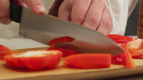 Cutting Sweet Red Pepper on Wooden Desk with Knife Closeup Macro Woman Hand Cut Vegetables Food