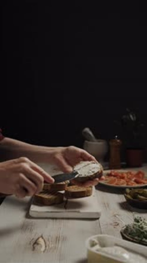 Close Up View Of Hands Spreading Cream Cheese On A Slice Of Bread