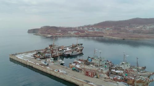 Drohnenaufnahme eines alten rostigen Schiffes, das im Hafen festgemacht hat, verlassene Schiffe, die die Umwelt verschmutzen