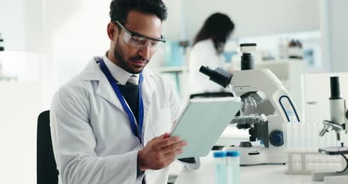 Scientist Reviews Data on Tablet in Bright Laboratory