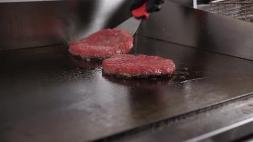 Beef Patties Cooking on Restaurant Metal Griddle