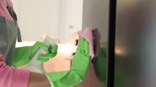 Woman Cleaning Refrigerator with Spray and Microfiber Cloth