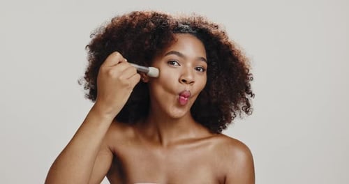 Studio, woman and brush for makeup, smile or foundation on skin with cosmetics, face or happy