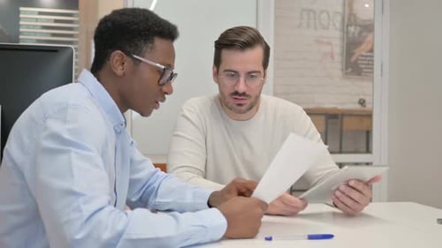 Two Young Adults Collaborating in an Office