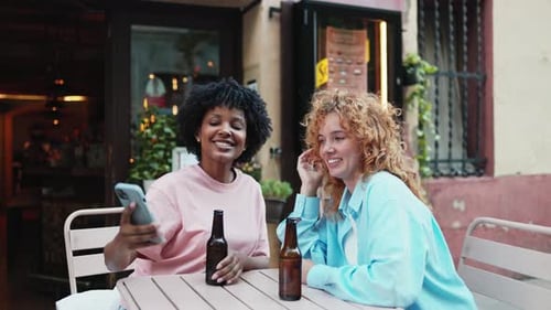 Multiethnic Friends Enjoying Drinks and Taking Selfies at Outdoor Cafe