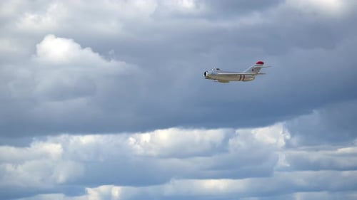 Vintage Jet Flies Against a Cloudy Blue Sky