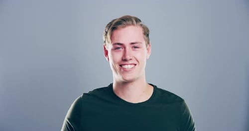 Young Adult Man Smiles and Makes Heart Shape