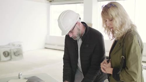 Project manager and client reviewing plans in an empty toronto office space