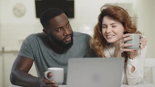 Couple Laughing and Drinking Coffee at Home