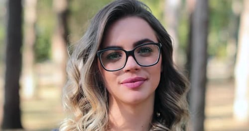 Pretty woman wearing glasses looking to camera smiling