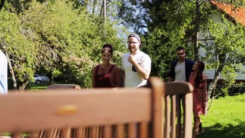 Friends Enjoying Outdoor Party in Backyard on Sunny Day