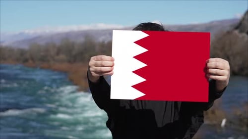 Personne tenant une bannière avec le drapeau du Bahreïn
