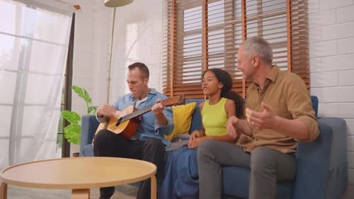 Family Sings and Plays Guitar in Living Room