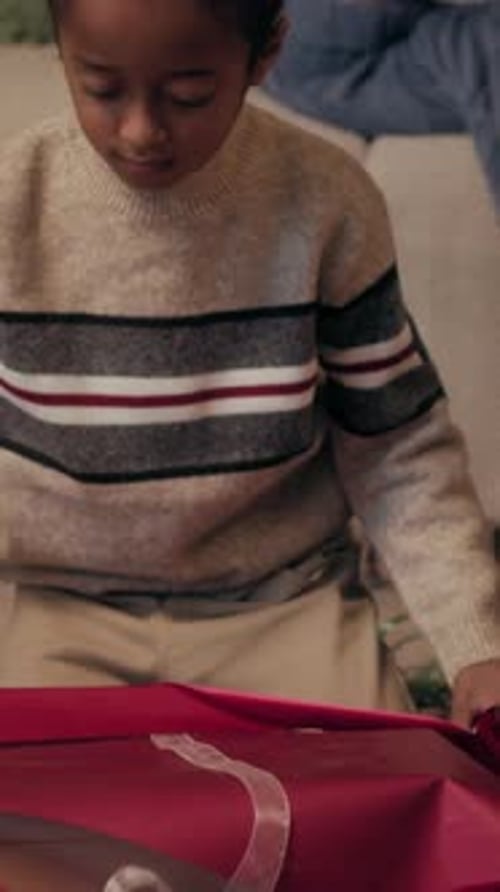 Boy Wrapping Christmas Present at Home