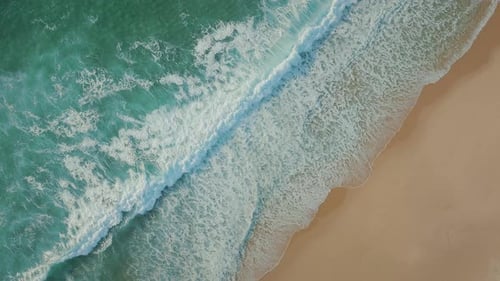 Big turquoise ocean tides moving towards the sandy tropical beach, creating abstract sea motion.