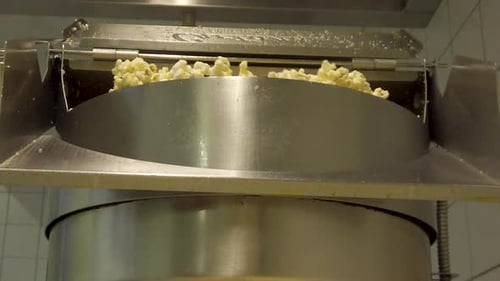 Kernels Burst Open the Container, Cascading with Freshly Popped Corn in slow motion