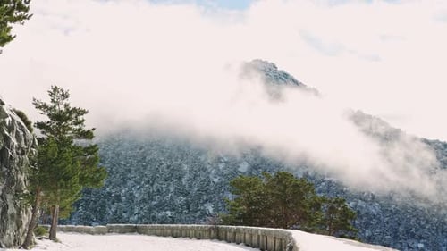Majestic Mountain Peaks Surrounded by Thick White Clouds in the Sunlight