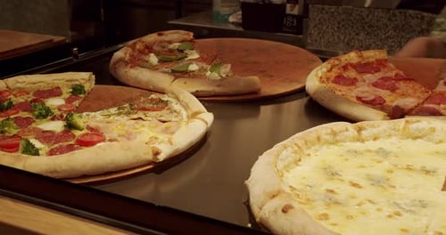 Lots of Pizza slice on the Table in a Pizzeria. Delicious Pizza.