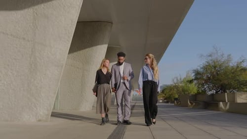 Colleagues Walking and Talking Outside Office Building