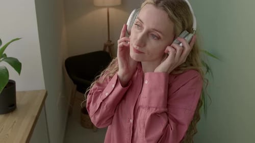 Woman with Headphones Enjoys Music and Dances