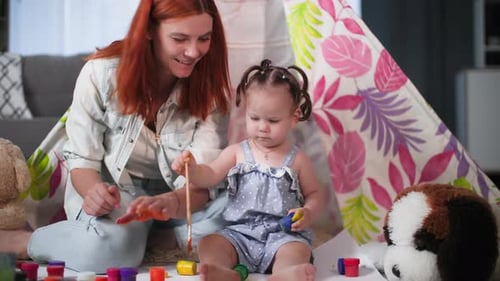 Creative Approach in Raising a Child a Cheerful Woman and a Little Girl Draw Pictures with Paints
