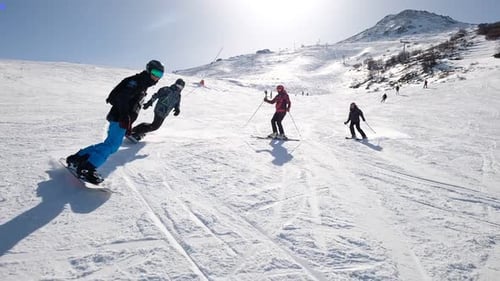 Young People Snowboarding In The Mountain