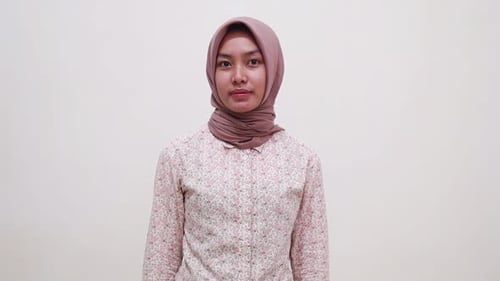 Fröhliches junges asiatisches muslimisches Mädchen steht und zeigt Daumen hoch. Isoliert auf weißem Hintergrund
