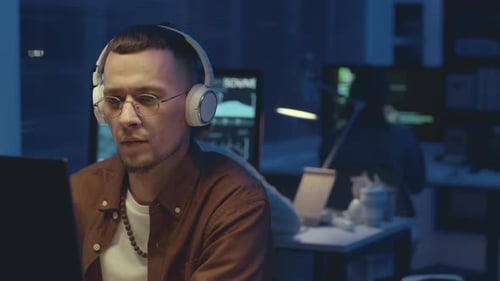 Technician Working on Computer in Office at Night