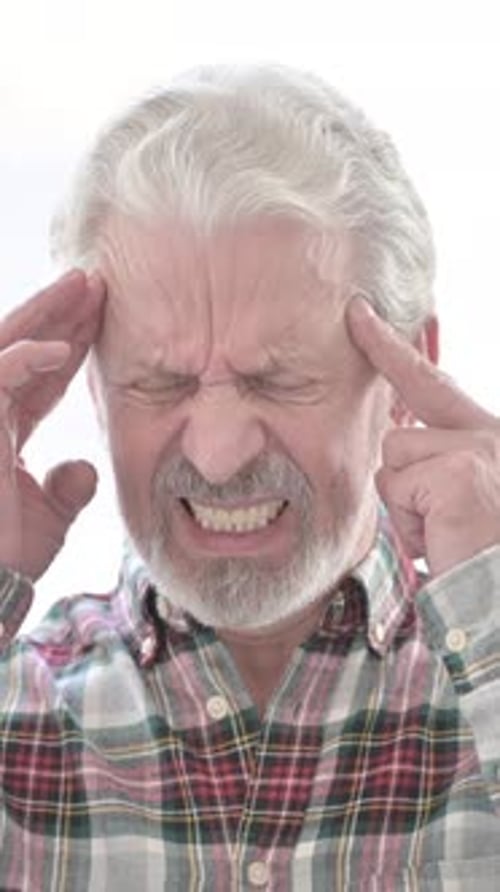 Senior Man Experiencing a Headache and Applying Pressure