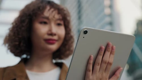 Close Up View of Asian Woman Hand Holding Digital Tablet Scrolling Videos Outside