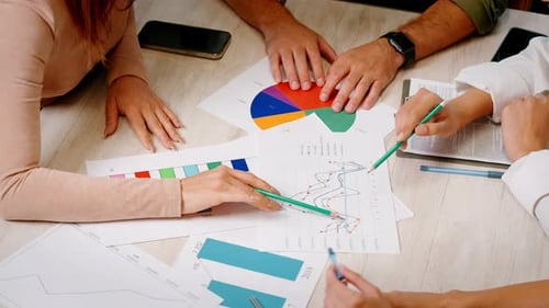 Team of Coworkers Studies Statistical Documents in Office