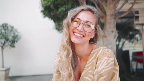 Smiling Blonde Woman Using Cellphone Outdoors