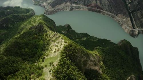 The Peak of the Mountain Illuminated By the Sun Against the Background of a Mountain River