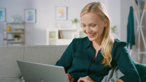 Woman Using Laptop Computer on Couch at Home