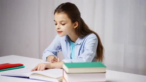 Girl Writing and Studying at Home at Desk