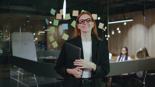 A Professional Woman is Shown Working in an Office Setting Surrounded By Colorful Sticky Notes and