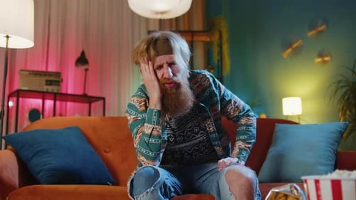 Un hippie mécontent se frotte les tempes pour soigner un problème de maux de tête dû à la migraine
