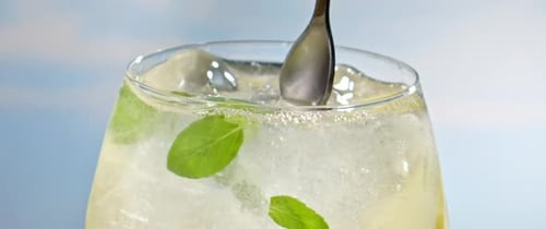 Sparkling Lemonade Refresher with Fresh Mint Stirred in Glass