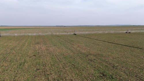 Aerial view of a modern pivot irrigation system irrigating a vast agricultural field. 4k.