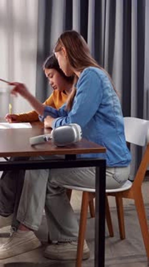 Two Women Collaborating Together at a Desk in Modern Office