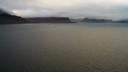 Luftaufnahme von magischen Fjorden und Hügeln, umgeben von Wolken, alles in Westfjorden.