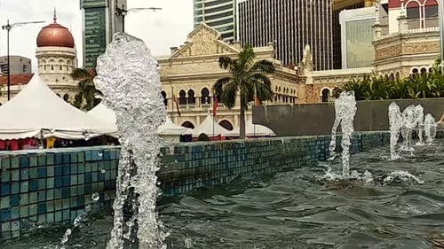 A
água cai de perto ou da fonte para uma pequena piscina na cidade. Câmera lenta