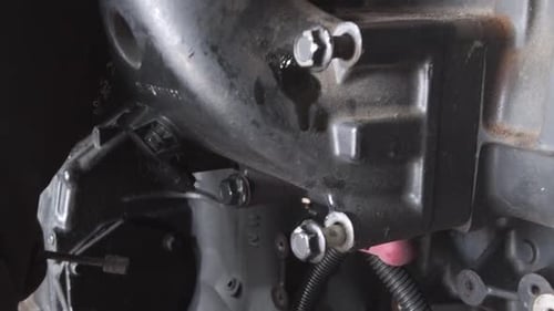 Hands Repairing a Shiny, Black Engine
