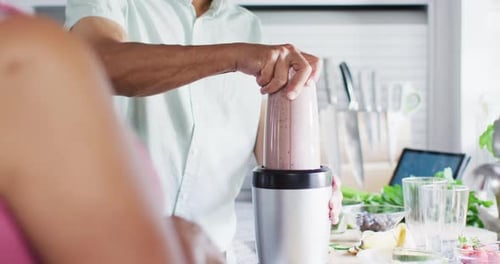 Smiling Senior Man Blends Smoothie at Home