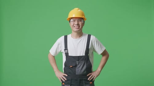 Asian Man Worker Wearing Goggles And Safety Helmet Standing With Arms Akimbo In The Green Screen