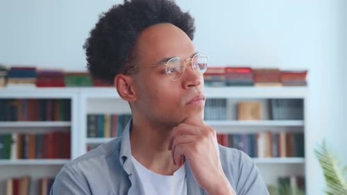 Man Indoors Thinking with Hand Under Chin