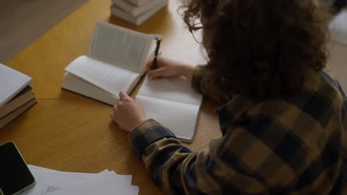 Young Adult Studying With Open Book at Desk