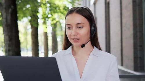 Woman with Headset Talking on Computer Outside