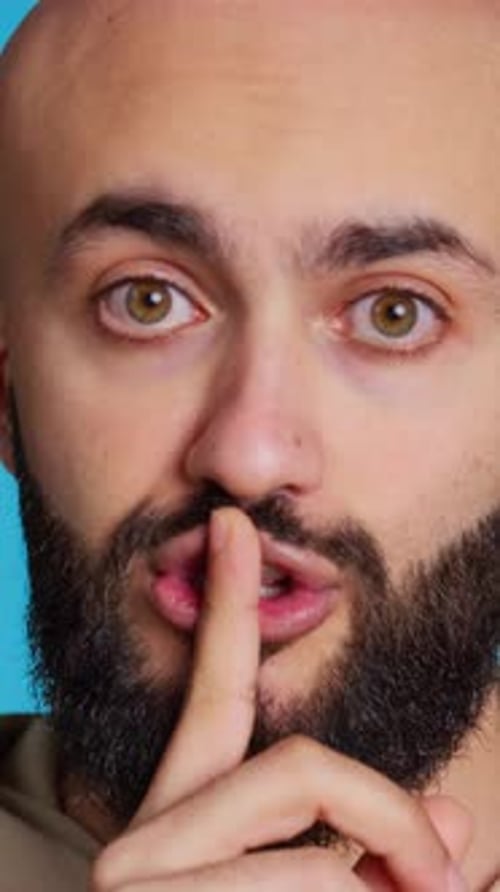 Vídeo vertical de una persona de Oriente Medio que muestra un gesto mudo con el dedo sobre los labios