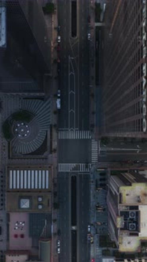 Flying Over Los Angeles Downtown Skyscrapers Top Down Revealing Helipads and Streets During Sunset